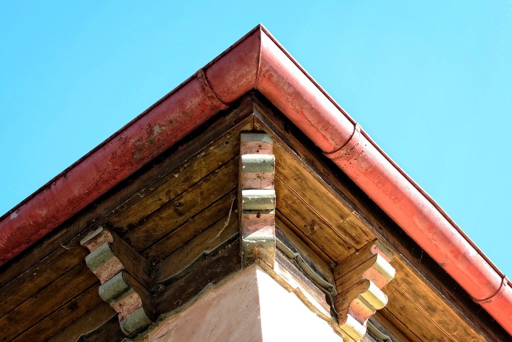 Gable end with copper-coloured guttering wrapping the corner of the roof