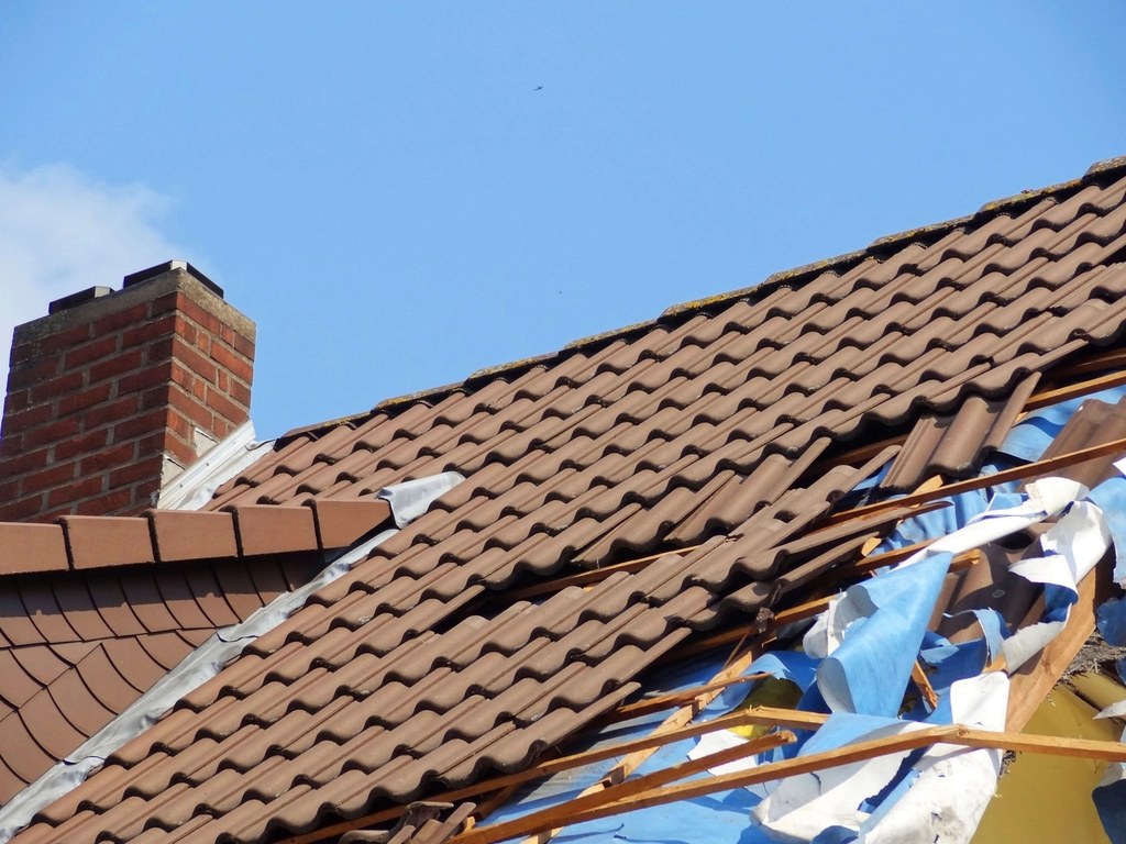 Pitched roof part way through re-tiling, with old tiles and membrane stripped back